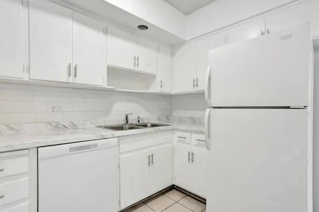 a kitchen with stainless steel appliances white cabinets and a refrigerator