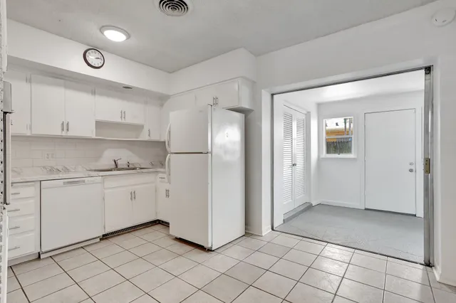 a kitchen with granite countertop white cabinets and stainless steel appliances