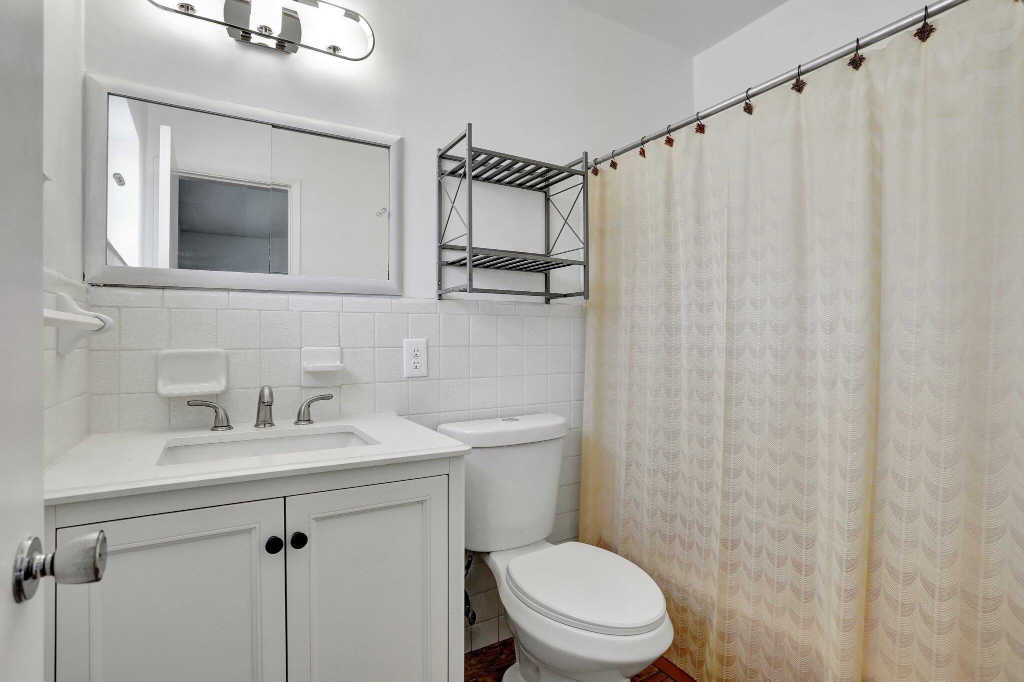 2540-2550 Northeast 10th Court, Unit 12 Pompano Beach, FL 33062 - Photo 19 of 25 a bathroom with a sink a mirror and a toilet