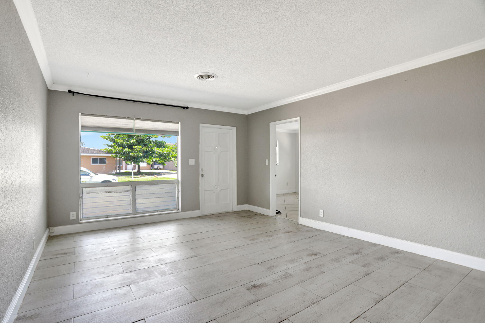 2540-2550 Northeast 10th Court, Unit 12 Pompano Beach, FL 33062 - Photo 2 of 25 an empty room with wooden floor and windows