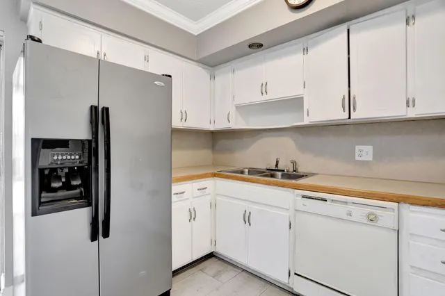 a kitchen with white cabinets and refrigerator