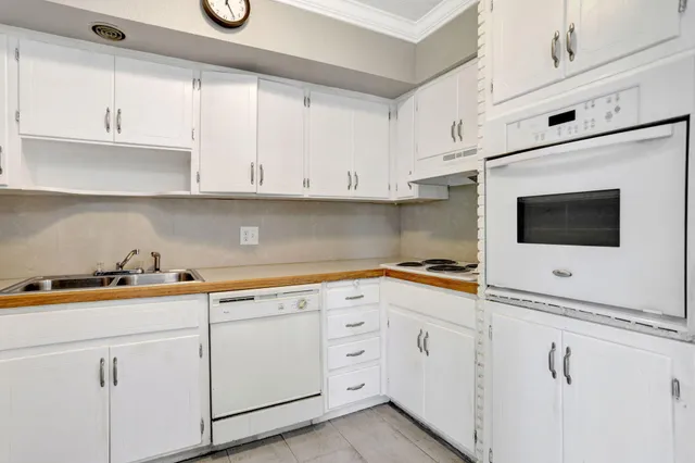 a kitchen with white cabinets and white appliances