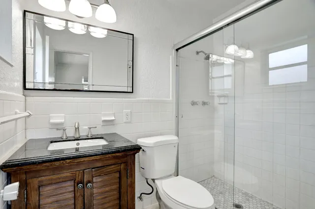 a bathroom with a sink a toilet and a mirror