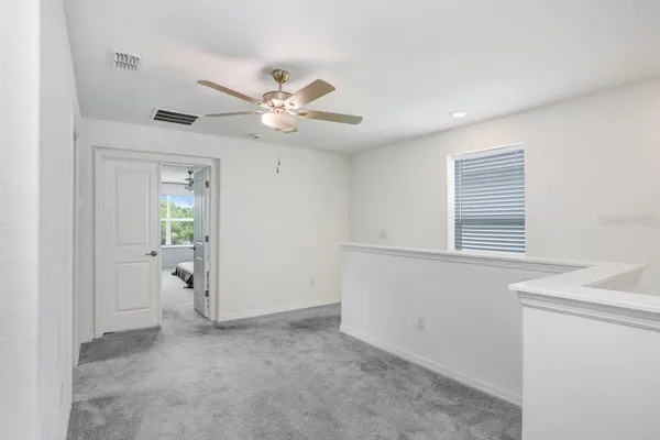 a view of a livingroom with a ceiling fan and window