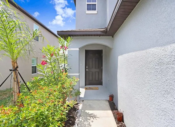 a front view of a house with plants