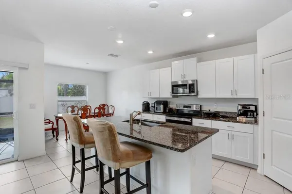 a kitchen with stainless steel appliances granite countertop a stove a sink a microwave and a refrigerator