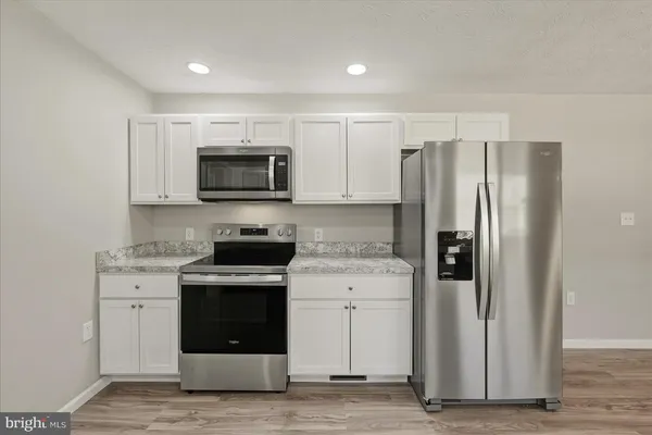 a kitchen with stainless steel appliances granite countertop a stove a refrigerator and a microwave