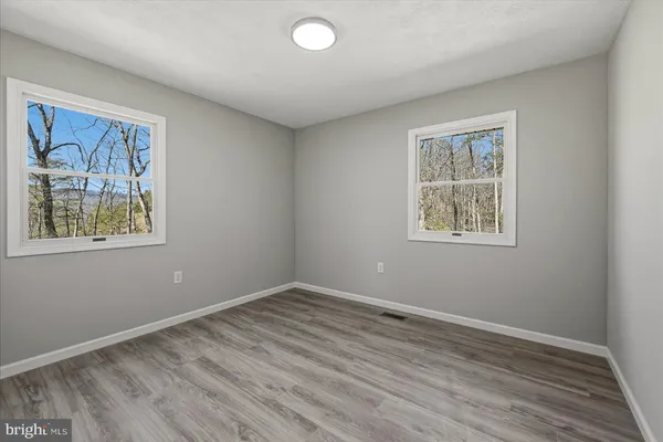 a view of room with window and wooden floor