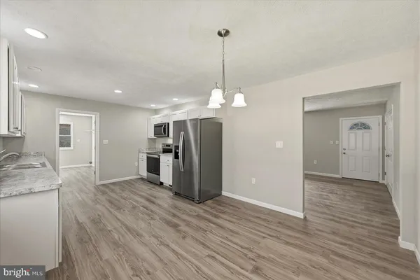 a view of a kitchen with a sink and dishwasher wooden floor