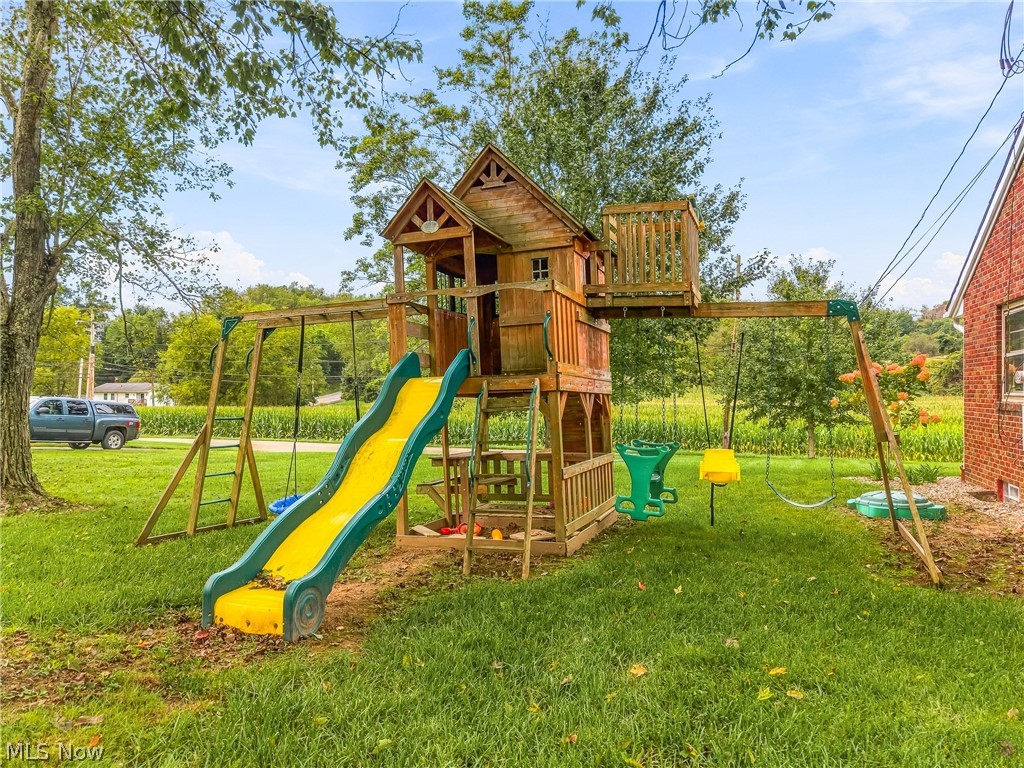3633 Blacksnake Hill Road Northeast Dover, OH 44622 - Photo 21 of 38 Outdoor play structure with a slide, swings, and an elevated playhouse