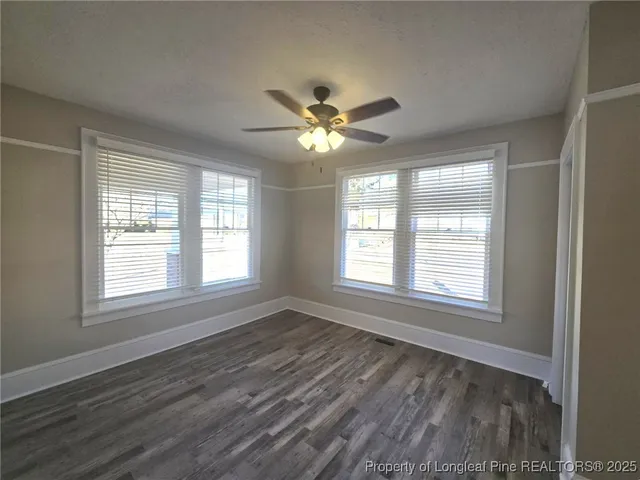 a view of an empty room with a window and a fan