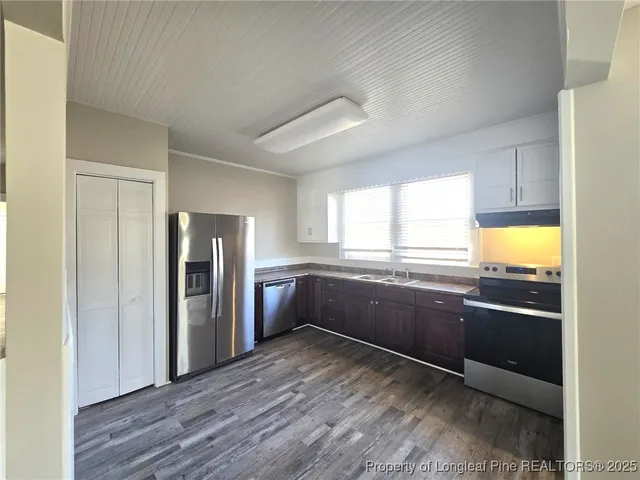 a kitchen with stainless steel appliances granite countertop a refrigerator and a sink