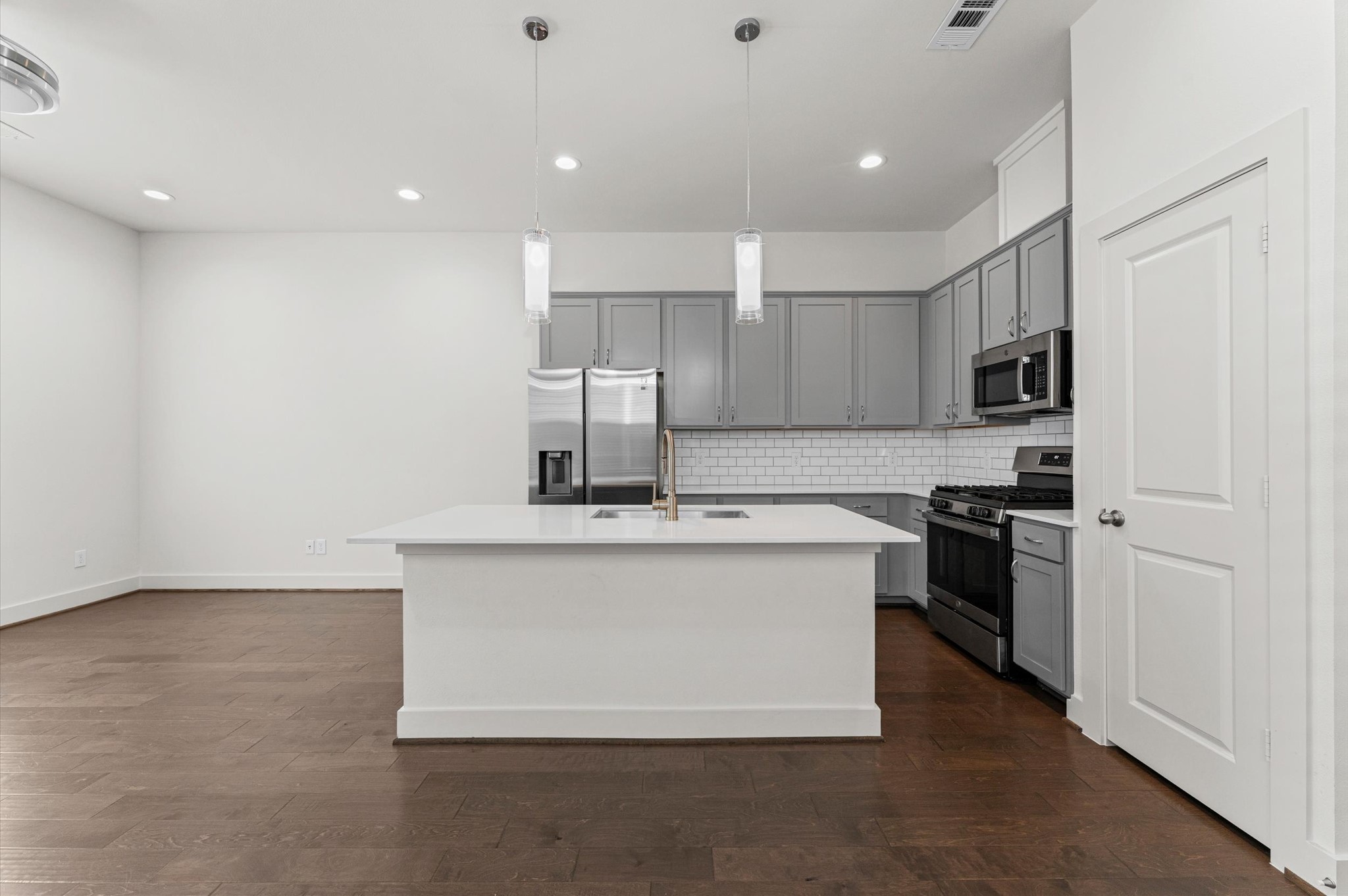 4163 Griggs Road Houston, TX 77021 - Photo 7 of 20 Kitchen features quartz countertops, gray shaker cabinetry, and stainless steel appliances.