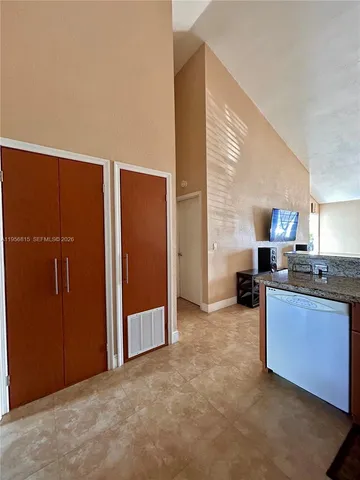 a view of kitchen with stainless steel appliances granite countertop cabinets and window