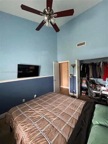 a bedroom with a bed and a ceiling fan