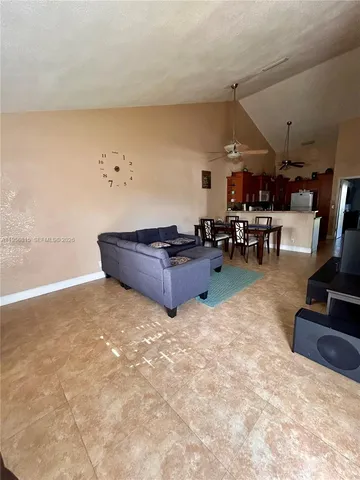 a living room with furniture and a dining table
