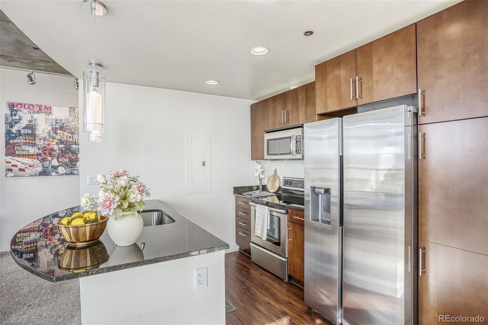 891 14th Street, Unit 1917 Denver, CO 80202 - Photo 8 of 29 a kitchen with stainless steel appliances granite countertop a refrigerator and a sink