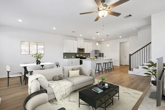 a living room with furniture kitchen view and a chandelier