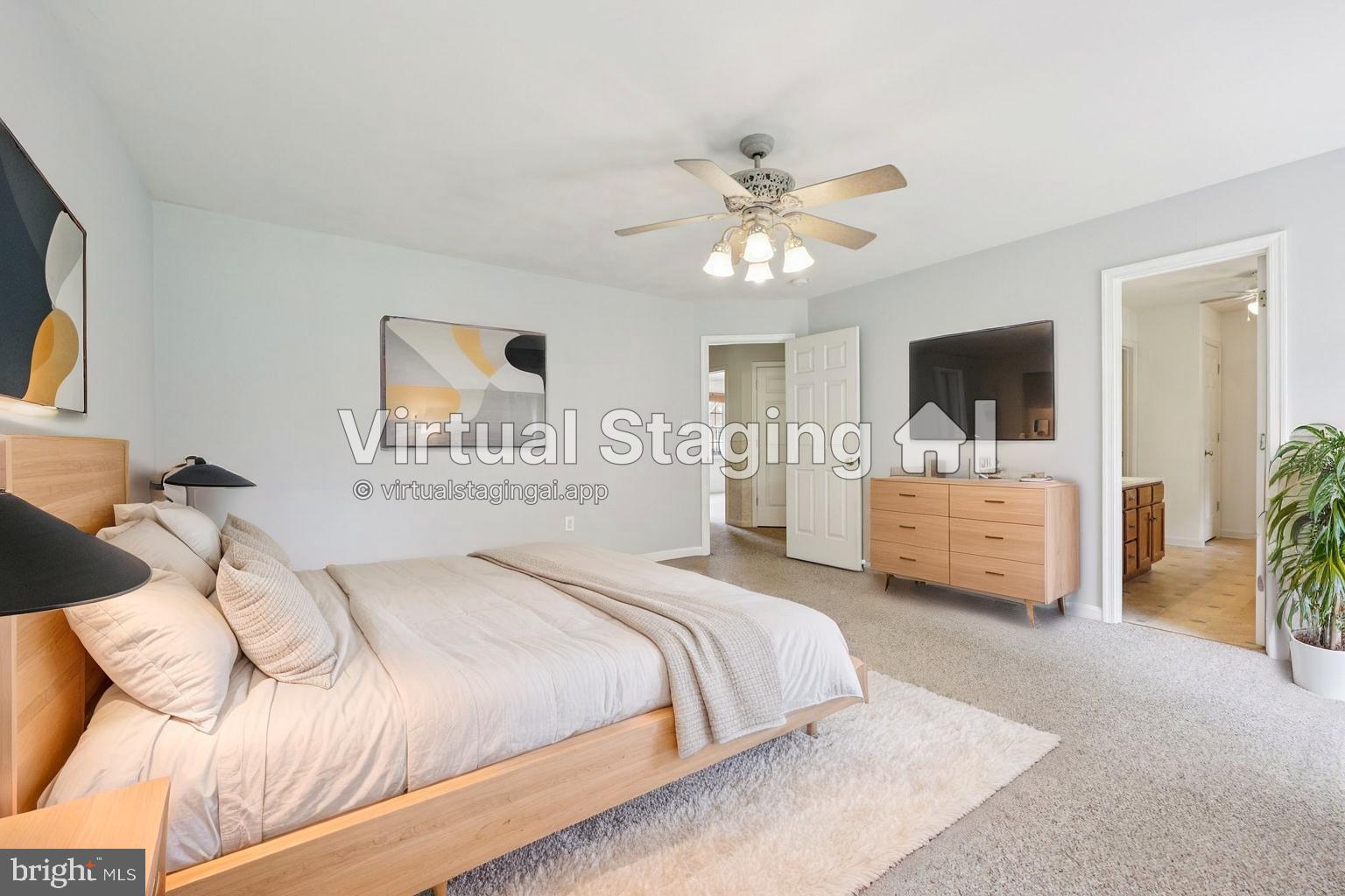 11607 River Meadows Way Fredericksburg, VA 22408 - Photo 32 of 67 a spacious bedroom with a bed a couch and a flat screen tv