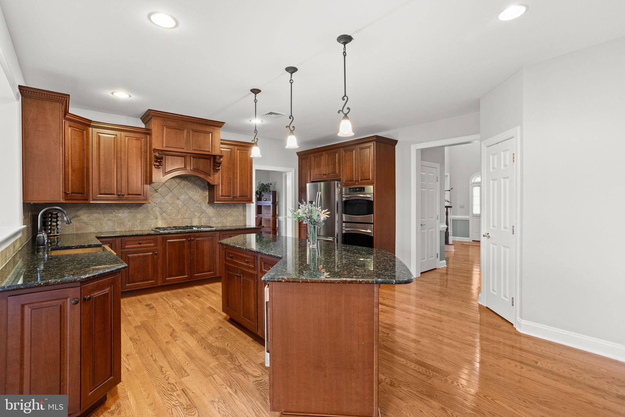 1368 Spring Hill Road Eagleville, PA 19403 - Photo 23 of 66 a kitchen with stainless steel appliances granite countertop a sink a stove and a wooden floors