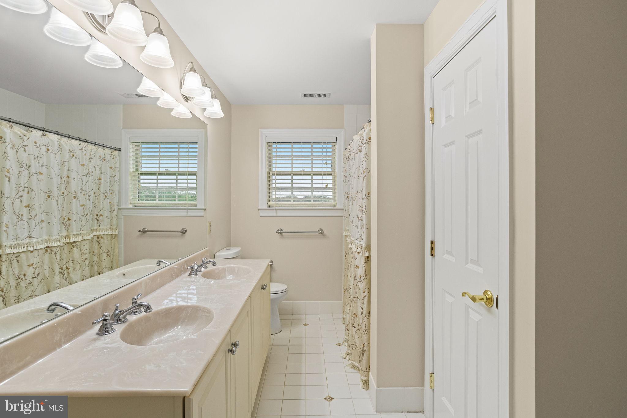 1368 Spring Hill Road Eagleville, PA 19403 - Photo 46 of 66 a bathroom with a granite countertop double vanity sink a mirror and a shower