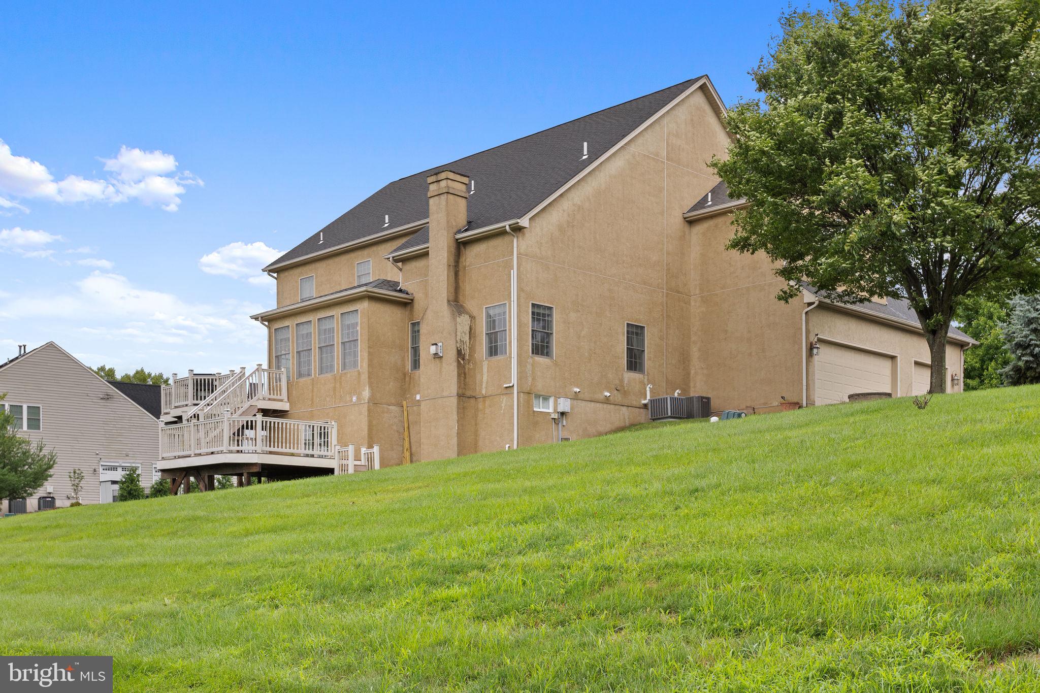 1368 Spring Hill Road Eagleville, PA 19403 - Photo 61 of 66 a backyard of a house with table and chairs plants and large tree