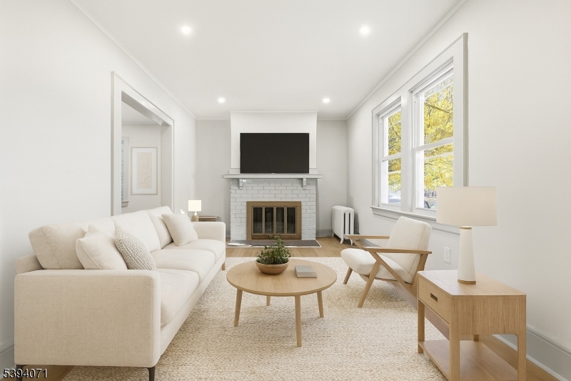 28 State Street, Unit 1 Bloomfield, NJ 07003 - Photo 2 of 8 a living room with furniture a fireplace and a flat screen tv