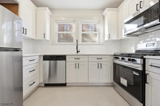 a kitchen with white cabinets and white appliances