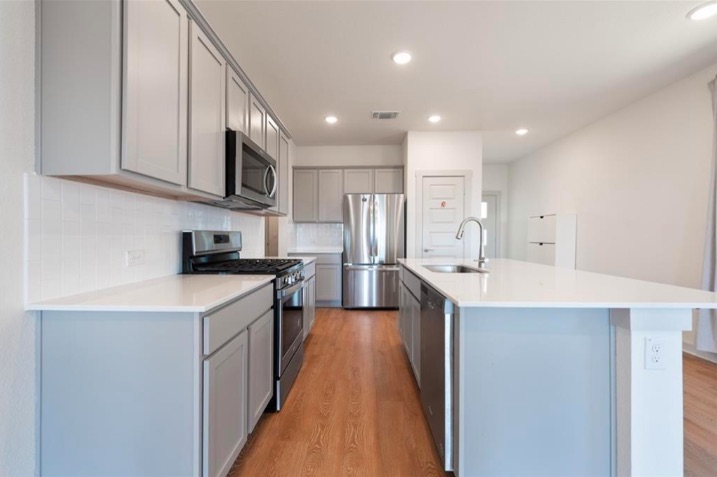 10805 Meris Lane Austin, TX 78754 - Photo 11 of 28 A well-lit kitchen with sleek countertops and stainless steel appliances.