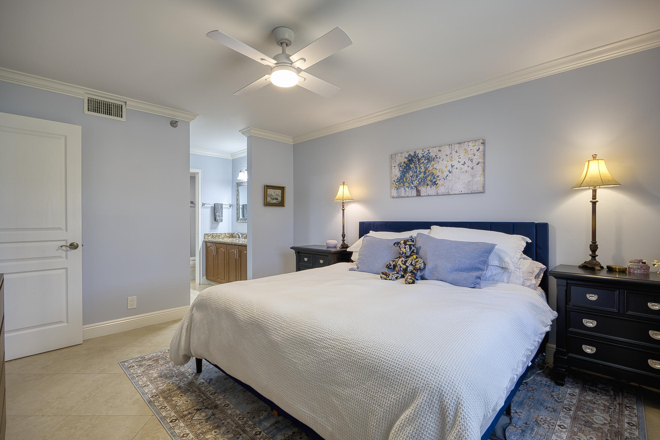 380 Northwest 67th Street, Unit 101 Boca Raton, FL 33487 - Photo 19 of 44 a bedroom with a large bed and a chandelier
