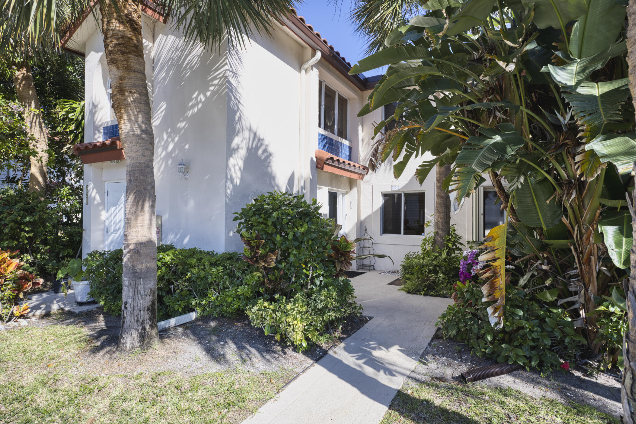 380 Northwest 67th Street, Unit 101 Boca Raton, FL 33487 - Photo 2 of 44 front view of a house with a garden
