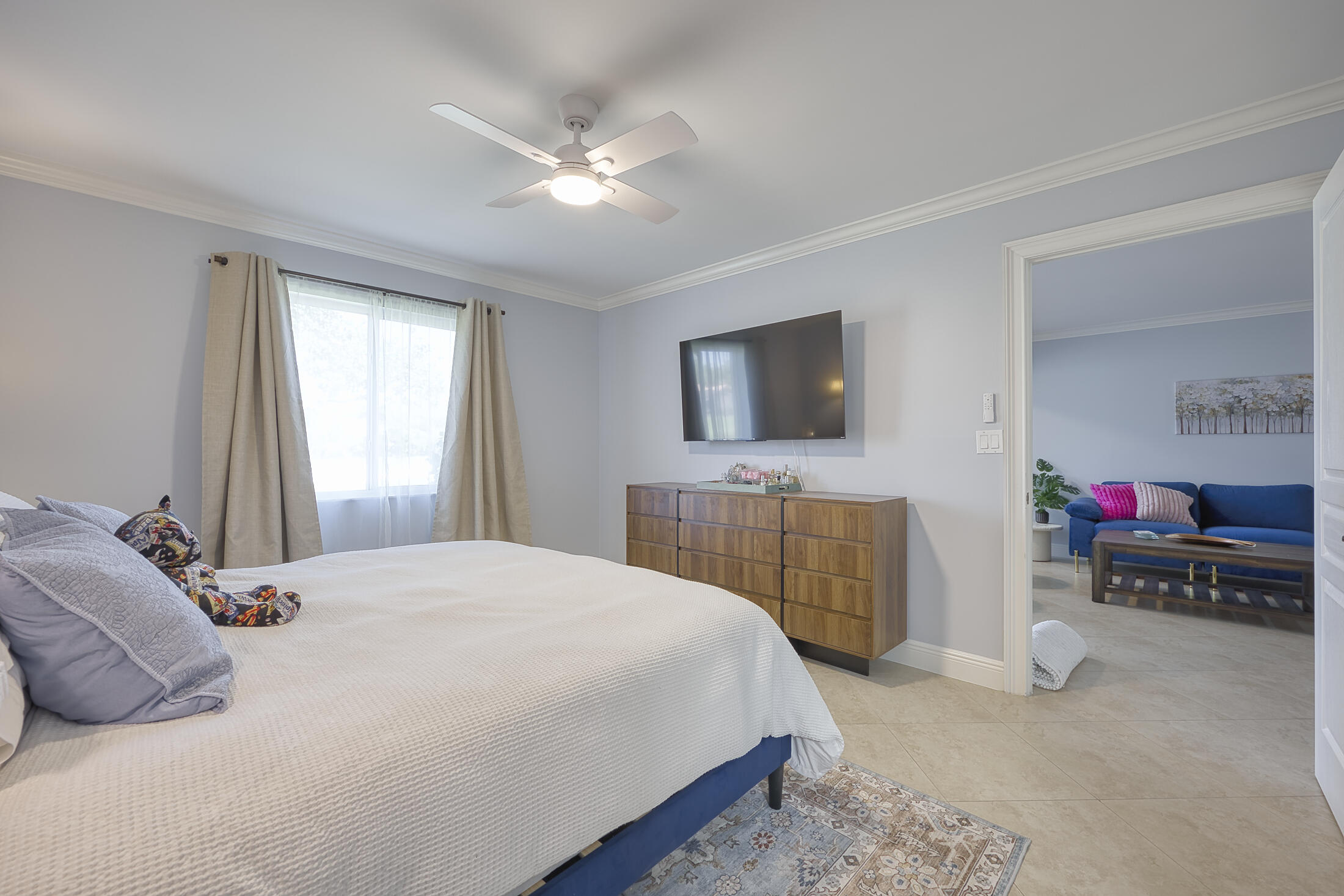 380 Northwest 67th Street, Unit 101 Boca Raton, FL 33487 - Photo 21 of 44 a bedroom with a bed and a flat screen tv