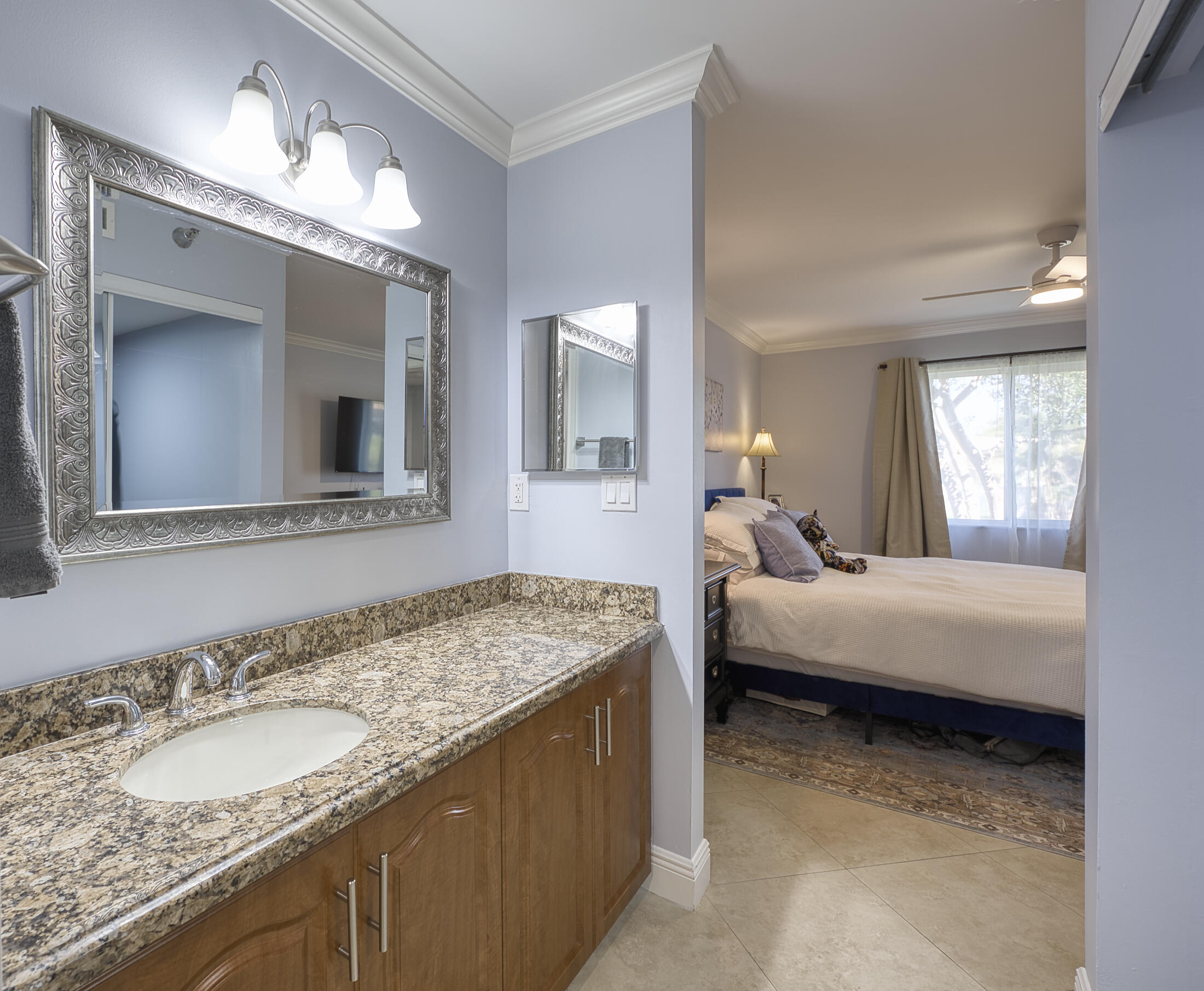 380 Northwest 67th Street, Unit 101 Boca Raton, FL 33487 - Photo 22 of 44 a en suite bathroom with a granite countertop sink and a mirror