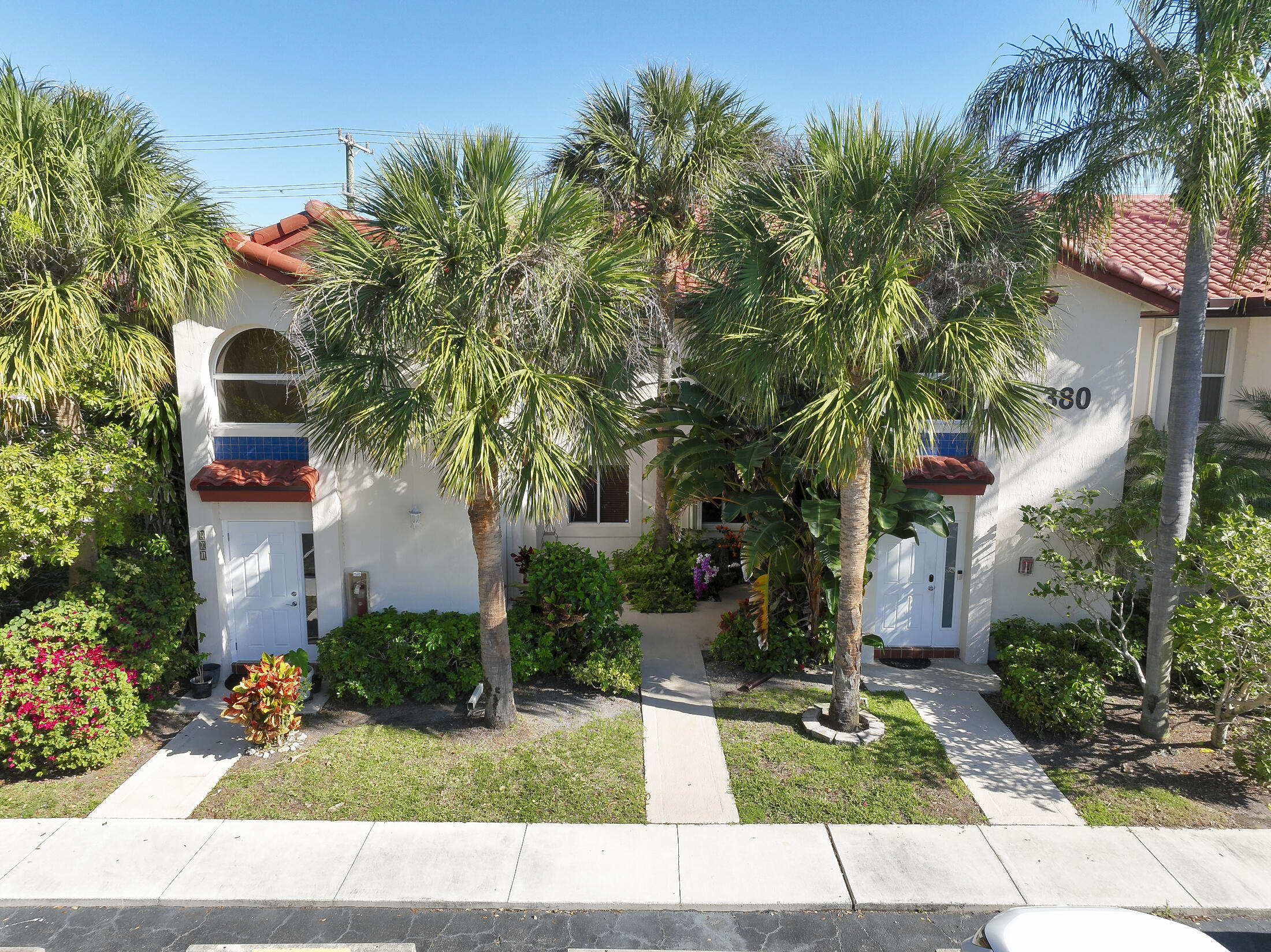 380 Northwest 67th Street, Unit 101 Boca Raton, FL 33487 - Photo 3 of 44 a view of multiple houses with a yard and potted plants