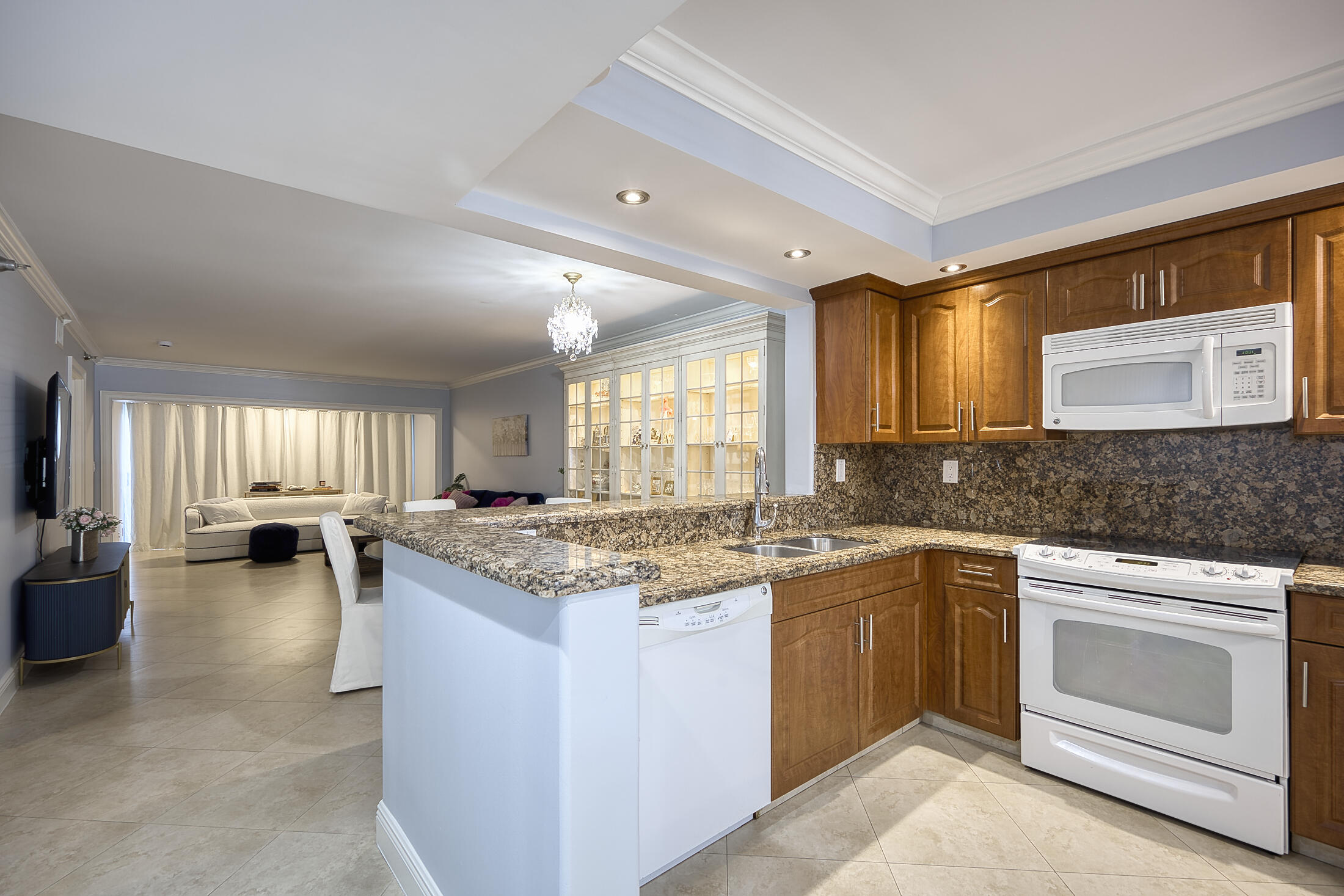 380 Northwest 67th Street, Unit 101 Boca Raton, FL 33487 - Photo 7 of 44 a kitchen with a stove a sink a center island and a window