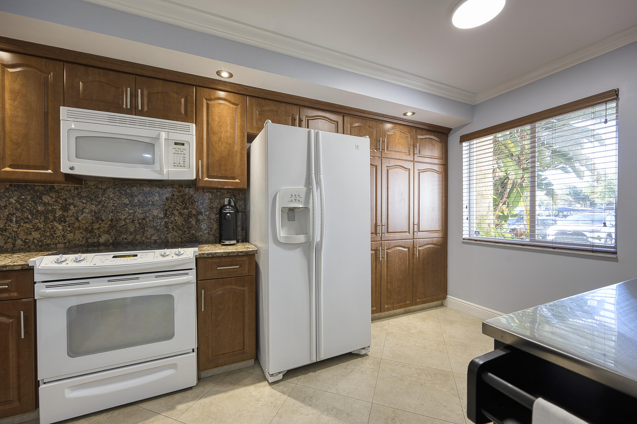 380 Northwest 67th Street, Unit 101 Boca Raton, FL 33487 - Photo 9 of 44 a kitchen with a stove microwave and refrigerator