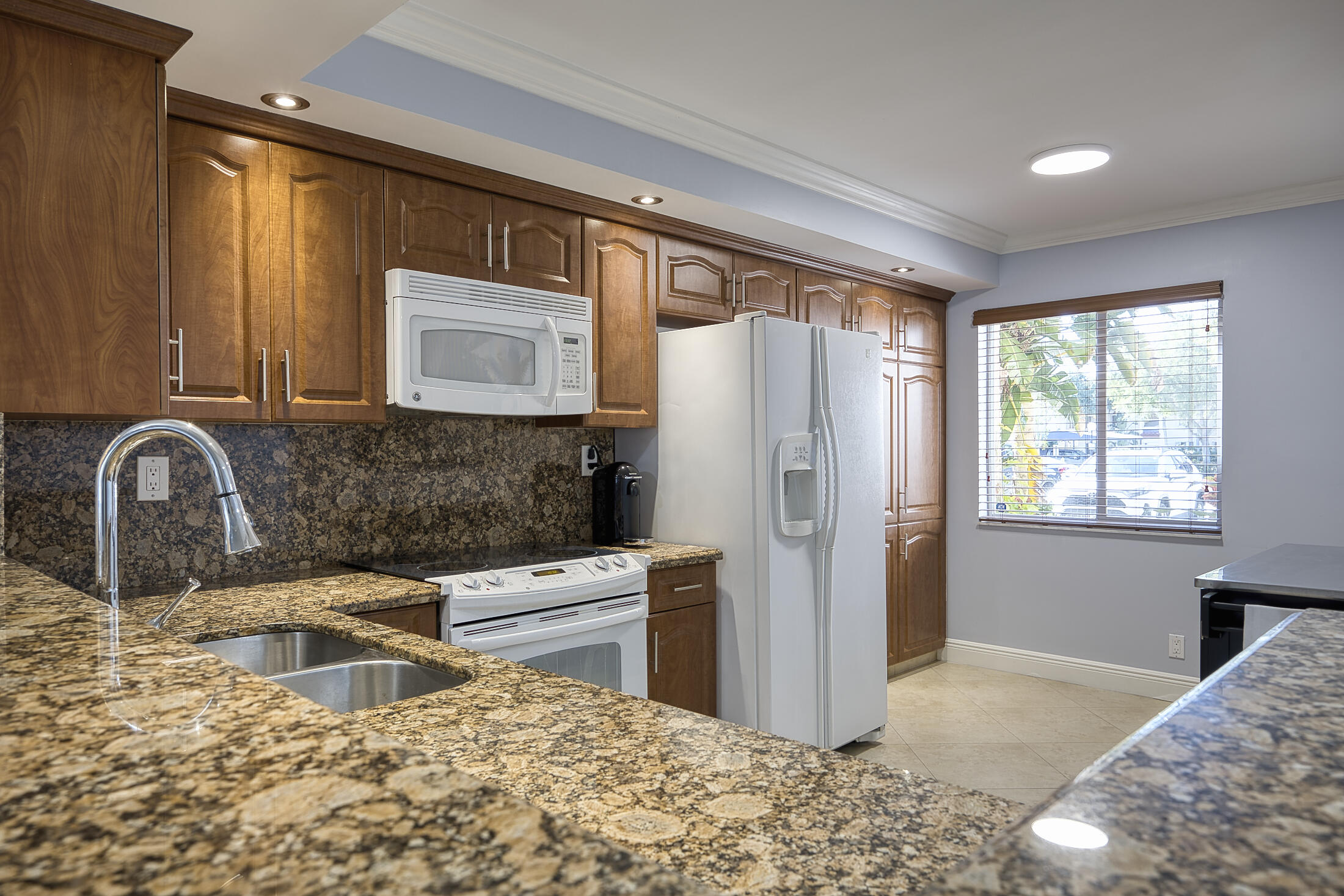 380 Northwest 67th Street, Unit 101 Boca Raton, FL 33487 - Photo 10 of 44 a kitchen with stainless steel appliances granite countertop a refrigerator and a sink