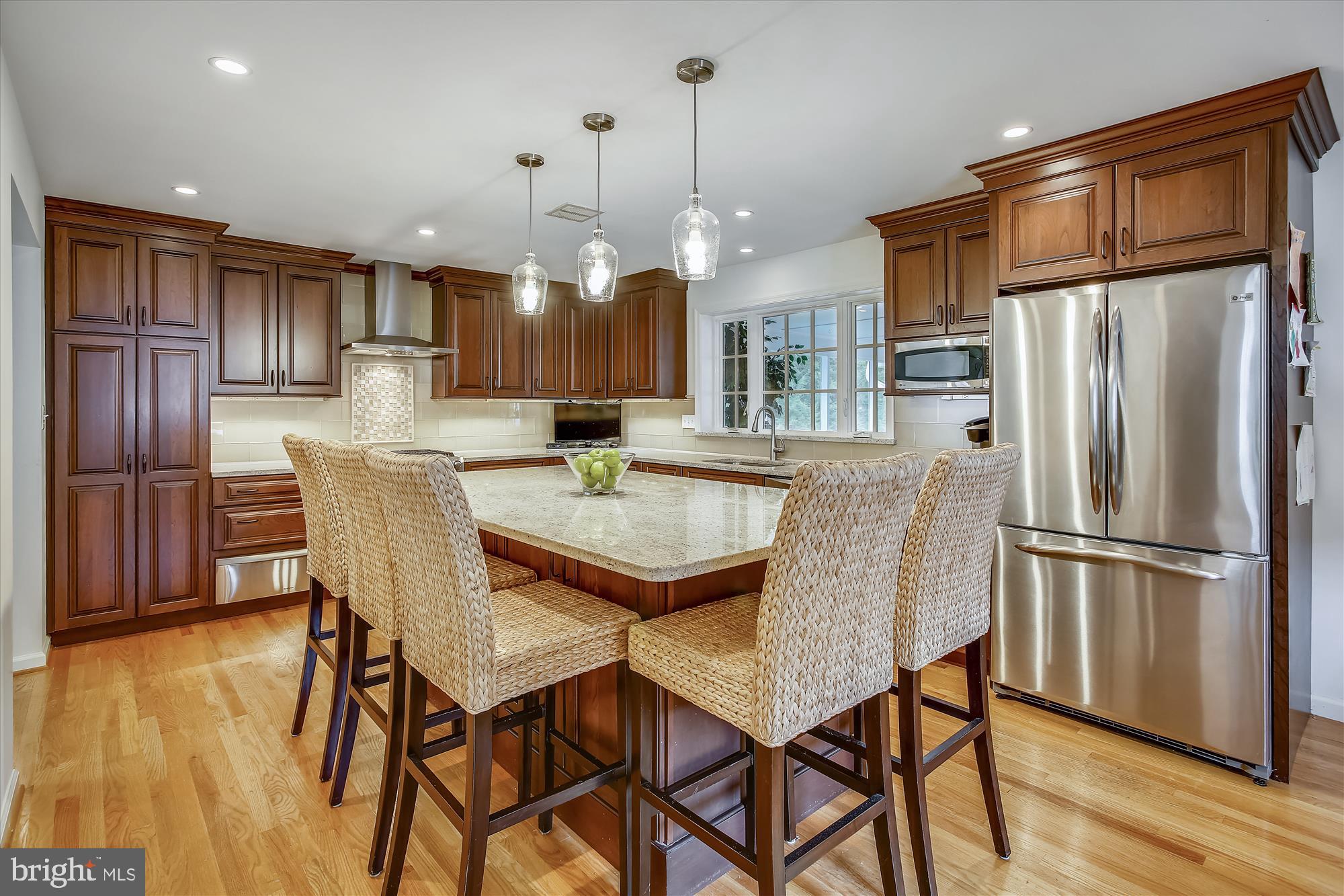 1437 Cola Drive McLean, VA 22101 - Photo 3 of 34 a kitchen with stainless steel appliances granite countertop a refrigerator a microwave a stove a dining table and chairs with wooden floor