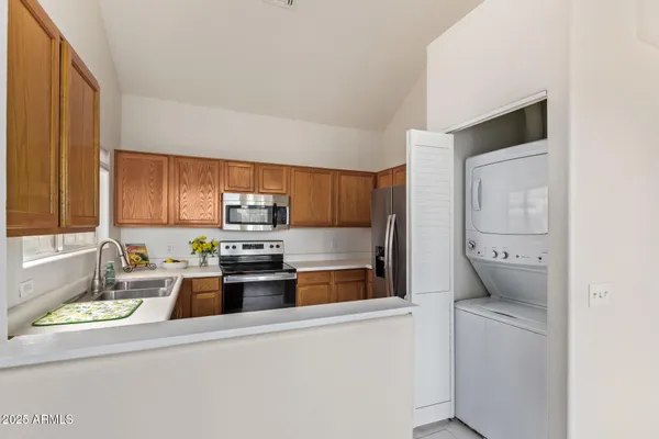 a kitchen that has a lot of white cabinets and stainless steel appliances