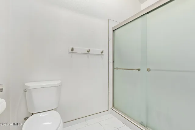 a white toilet sitting next to a shower