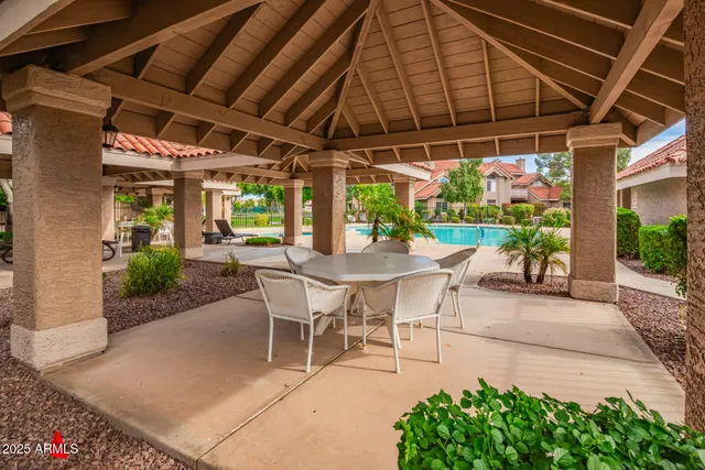a view of a patio with a table and chairs under an umbrella