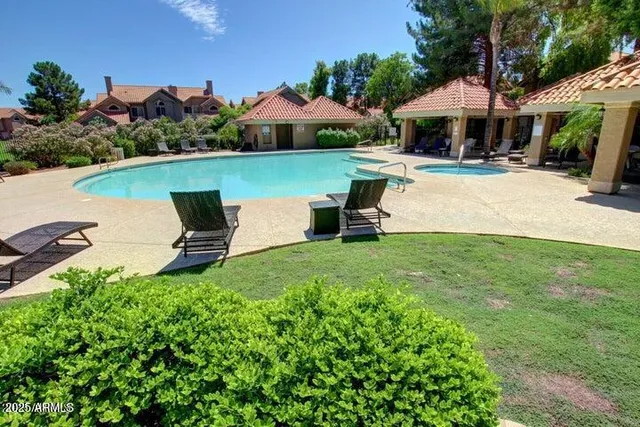 a view of a patio with table and chairs under an umbrella