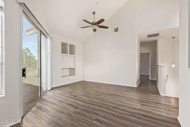 a view of a livingroom with wooden floor and a ceiling fan
