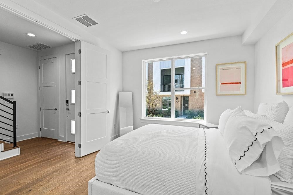 2805 McCurdy Street, Unit 7 Austin, TX 78723 - Photo 22 of 40 a spacious bedroom with a large bed and wooden floor