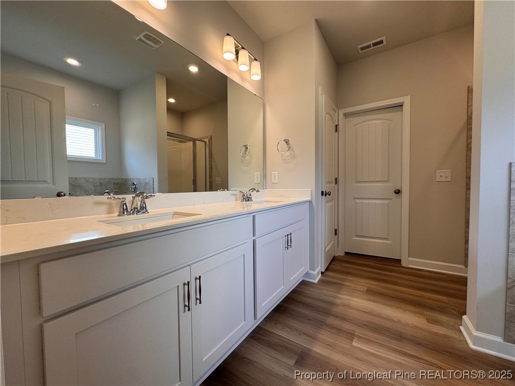 294 Elijah Way Vass, NC 28394 - Photo 16 of 33 a spacious bathroom with a double vanity sink a mirror and a shower