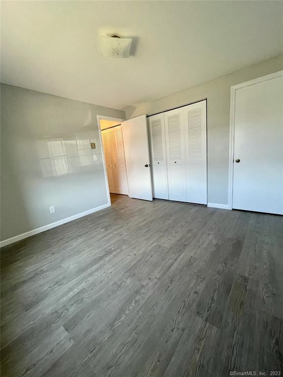 114 South Washington Street, Unit 24 Plainville, CT 06062 - Photo 10 of 14 an empty room with wooden floor and windows