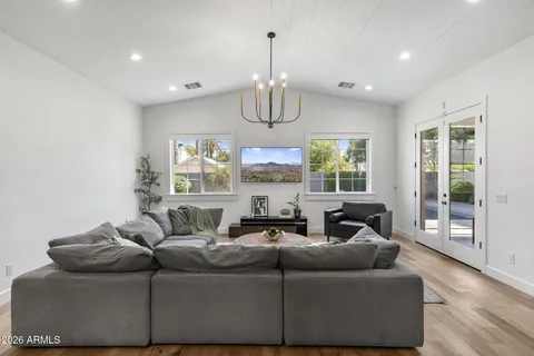 a kitchen with stainless steel appliances kitchen island granite countertop a dining table chairs and a refrigerator