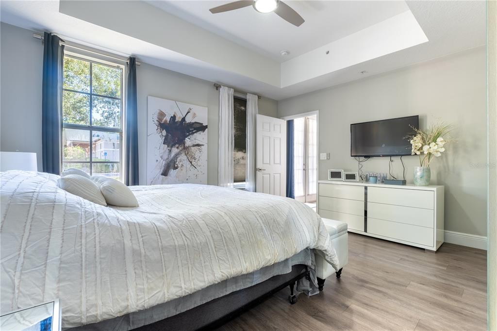 930 Spring Park Street, Unit 103 Kissimmee, FL 34747 - Photo 27 of 40 a bedroom with a large bed and a flat tv screen on dresser