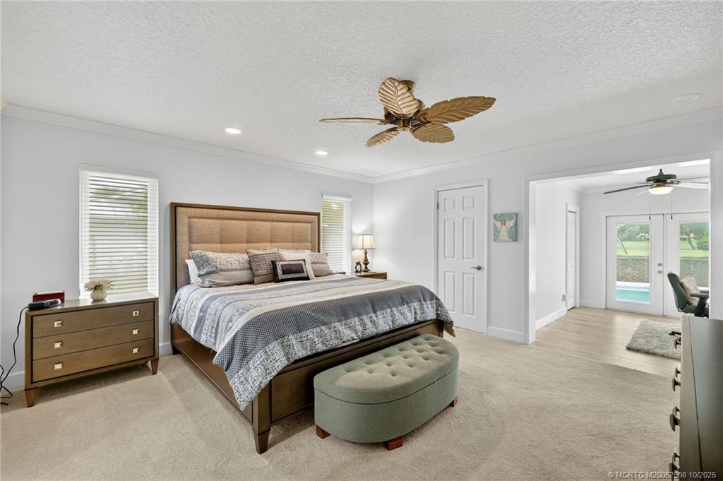 3353 Southeast Fairway East Stuart, FL 34997 - Photo 14 of 55 a spacious bedroom with a bed and ceiling fan
