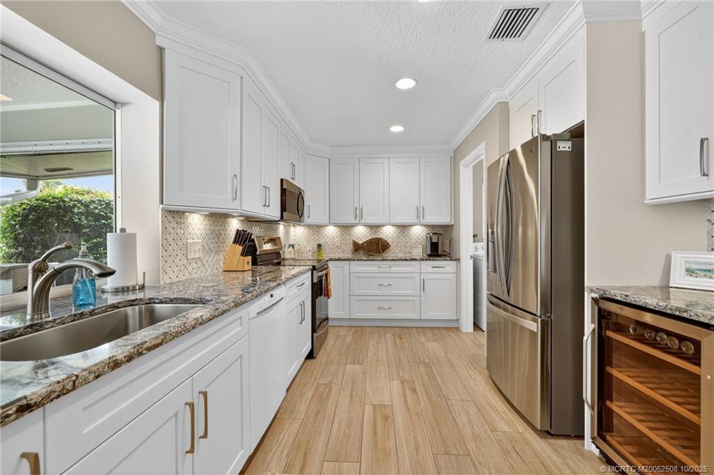 3353 Southeast Fairway East Stuart, FL 34997 - Photo 10 of 55 a kitchen with granite countertop a refrigerator stove and sink